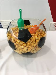 a glass bowl filled with popcorn on top of a table