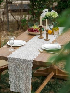 the table is set with white plates and place settings for two people to sit at