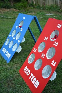 two red and blue cornhole game boards sitting in the grass
