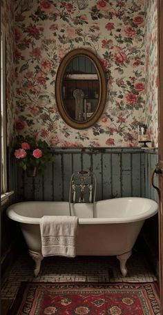 an old fashioned bathtub with flowers on the wall and rug in front of it