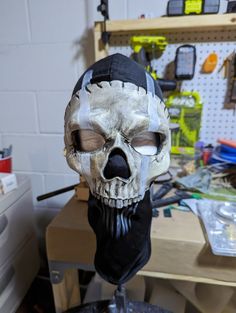 a skull mask is sitting on top of a workbench with tools and other items in the background