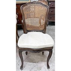 an antique chair with cane back and upholstered seat