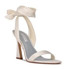 a women's white high heel sandal with a bow on the front and ankle