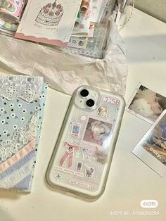 an iphone case sitting on top of a table next to pictures and other items in plastic bags