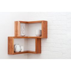 two wooden shelves on the wall with white dishes and vases in each one's compartments