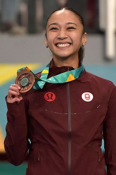 the woman is holding up her gold medal