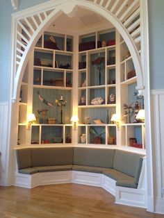 an arched window in the corner of a room with wooden floors and white trimmings