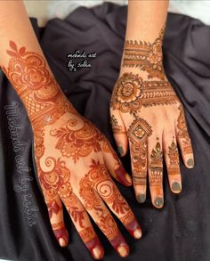 two hands with henna tattoos on them