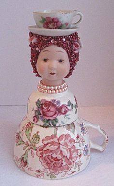 a figurine with a hat on top of it's head and flowers