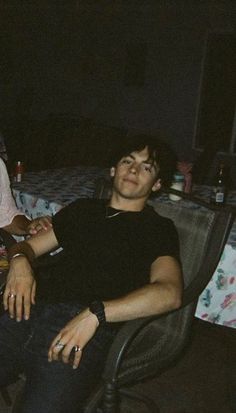 two young men sitting next to each other on a couch in a living room at night