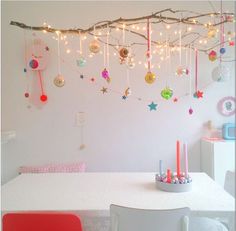 a white table topped with lots of christmas decorations and lights hanging from it's ceiling