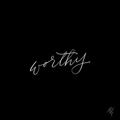 the word worthy written in cursive writing on a black background with white ink