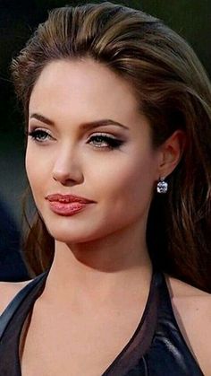 a close up of a woman with long hair and wearing earrings on her left ear