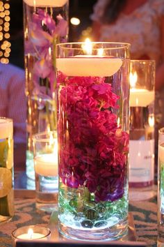 several vases filled with flowers and candles