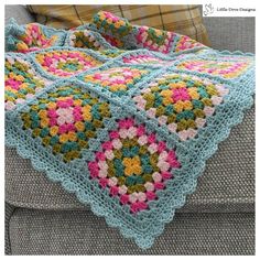 a crocheted blanket is sitting on a couch
