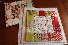 two pieces of quilt sitting on top of a wooden table