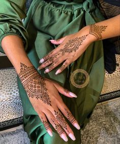 two hands with henna tattoos on them