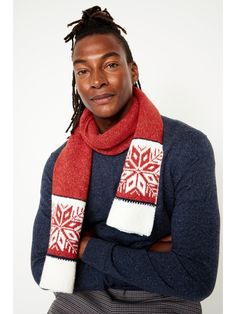 a woman with dreadlocks wearing a red and white knitted snowflake scarf