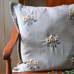 a pillow with flowers on it sitting on a chair