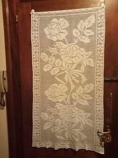 a white doily hanging on a wooden door