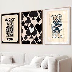 three framed art pieces hang on the wall above a white couch