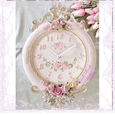 an ornate clock with pink flowers on it