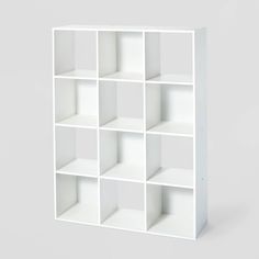 a white bookcase with twelve cubes on each side and one section missing from the top