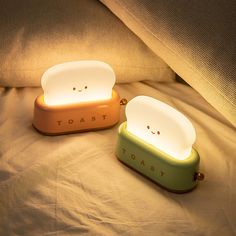 two toaster shaped lights sitting on top of a bed next to eachother