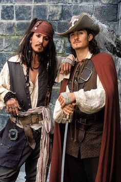 two men dressed in pirate costumes standing next to each other