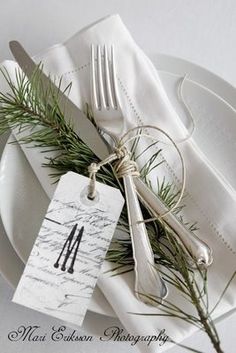 a white plate topped with a fork and knife next to an empty place setting on top of a table