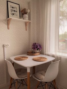 a white table with two chairs and a basket on it in front of a window