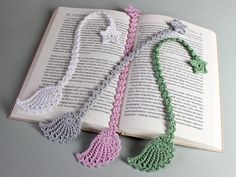 an open book with crocheted tassels on it