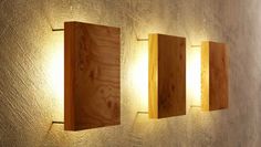 three wooden lights are mounted on the wall