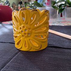 a yellow vase sitting on top of a table
