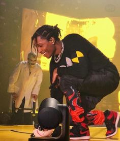 a man bending over on top of a black object in the middle of a stage