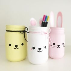 three mason jars with bunny and cat faces painted on them