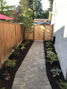 a brick walkway leading to a wooden fence