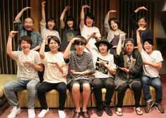 a group of people sitting on top of a couch in front of a wooden wall