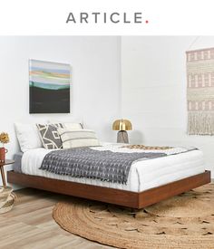 a bed sitting on top of a wooden floor next to a rug