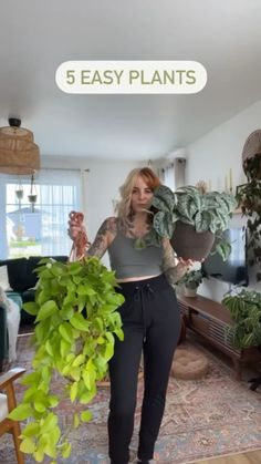 a woman standing in a living room holding a potted plant with the words 5 easy plants above her