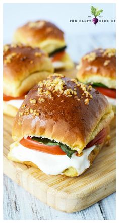 three sandwiches on a cutting board with cheese and tomatoes in the middle, topped with bread crumbs