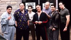 a group of men standing next to each other in front of a building with signs on it