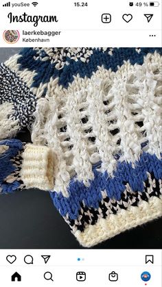 a blue and white knitted blanket laying on top of a table