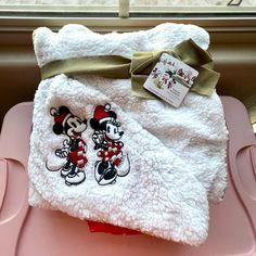 a white towel with mickey and minnie on it sitting on top of a pink tray