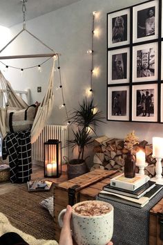 a living room filled with furniture and pictures hanging on the wall next to a fire place