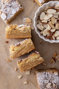 several pieces of cake next to a bowl of almonds