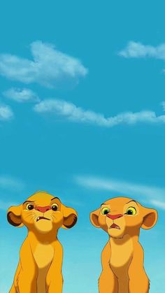 two lions sitting next to each other in front of a blue sky with white clouds