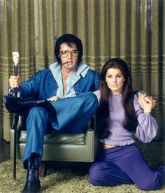 a man and woman sitting on a chair with one holding a wand in their hands