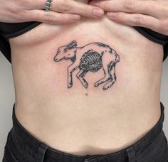 a woman's stomach with a horse skeleton tattoo on the side, and her hands over her belly