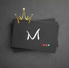 three black business cards with the letter m and a gold crown on top, sitting next to each other